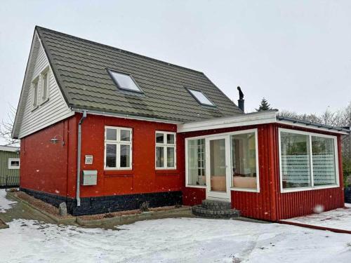 a red house with snow in front of it at Holiday home Rønne VI in Rønne