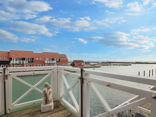 a statue of a dog sitting on a fence near the water at Beautiful holiday home in Borre-By Traum in Borre