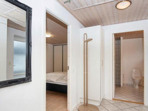 Holiday home Ørsted V في Ørsted: غرفة نوم مع مرآة وسرير