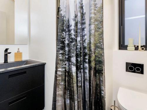 a bathroom with a shower curtain of a forest at 5 star holiday home in Frederikshavn-By Traum in Frederikshavn