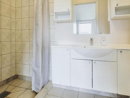 y baño blanco con lavabo y ducha. en Holiday home Bogense XLVI, en Bogense