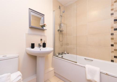 ein Badezimmer mit einem Waschbecken, einem WC und einer Badewanne in der Unterkunft Derby Parliament Spacious 2Bedroom Apartment with Parking in Derby