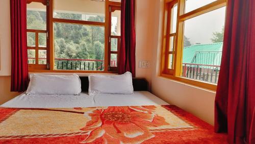 a bed in a room with two windows at Sweet Dreams in Dharamshala