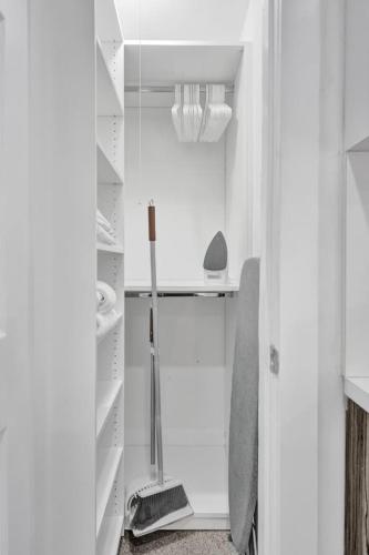 a white walk in closet with a glass door at Coastal Charm Studio Retreat in Pompano in Pompano Beach