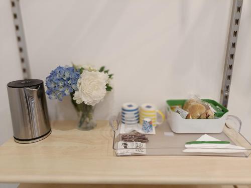 a table with a trash can and flowers on it at Casa di Nonna Margherita in Trecase