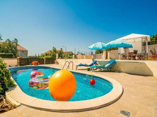 uma piscina com uma bola de laranja e uma bola de laranja em Dubrovnik Chalets em Čilipi