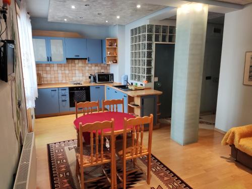 a kitchen with blue cabinets and a table and chairs at Rila Apartment in Samokov