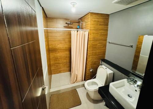 a bathroom with a toilet and a sink and a shower at City Homes: The Radiance Manila Bay in Manila