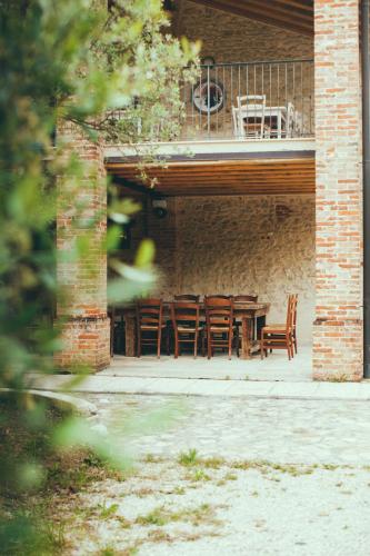 a patio with a table and chairs on a balcony at Asolo Norah's Hill Agri Rooms in Caenere