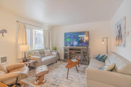 a living room with white furniture and a flat screen tv at Alaska Daydream Retreat Near Downtown in Fairbanks
