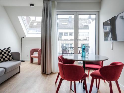 a living room with a table and chairs and a couch at numa I Leo Apartments in Düsseldorf