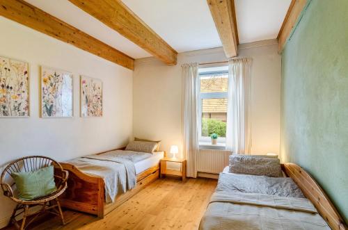 sypialnia z 2 łóżkami i oknem w obiekcie Gulfhof Oldersum Erdgeschoss w mieście Moormerland