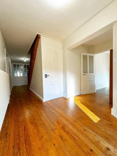 an empty room with a wooden floor and white walls at Chalet Cosy Lisière de Forêt in Xonrupt-Longemer