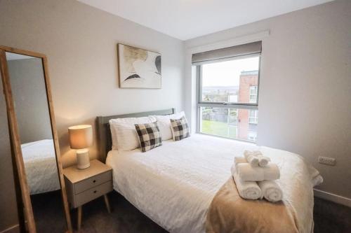 a bedroom with a bed and a mirror and a window at City Retreat by the Castle Free Designated Parking in Stirling