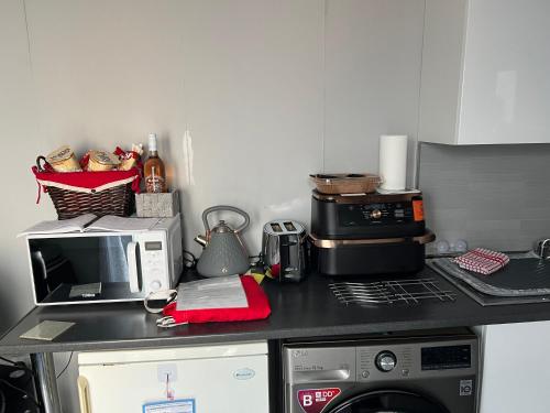 a kitchen with a counter top with a microwave and a stove at Craigellachie Cabin in Aviemore