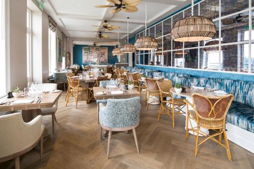 un restaurante con mesas y sillas de madera y paredes azules en Harbour Hotel Fowey, en Fowey