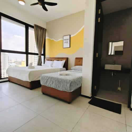 a hotel room with two beds and a window at Cozy & Drive Urban Suite by WL in Jelutong