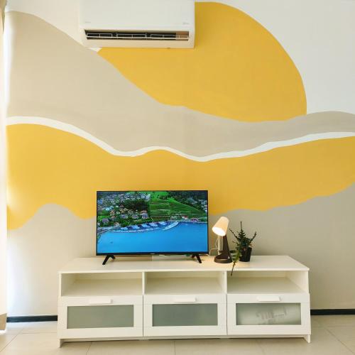 a living room with a flat screen tv on a wall at Cozy & Drive Urban Suite by WL in Jelutong