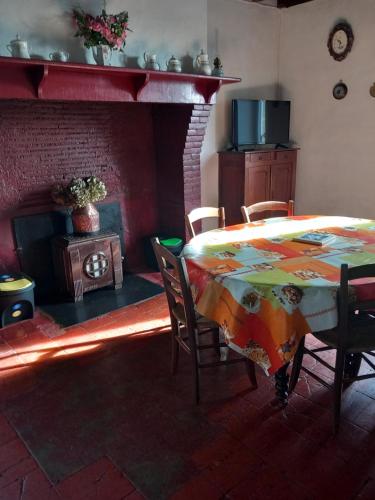 Panjas的住宿－Maison de campagne Les Chênes.，一间带桌子和壁炉的用餐室