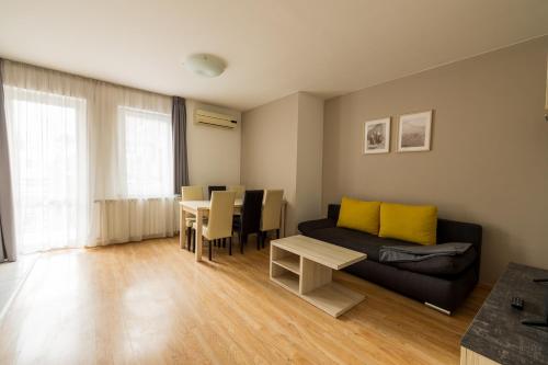 ein Wohnzimmer mit einem Sofa und einem Tisch in der Unterkunft Maple Tree Budget Apartments in Budapest