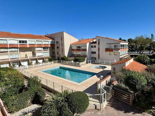 un complexe d'appartements avec une piscine et deux bâtiments dans l'établissement Studio Cabine 4 Pers, Piscines, Proche Plage, Parking Privé - Argelès-sur-Mer - FR-1-225-92, à Argelès-sur-Mer