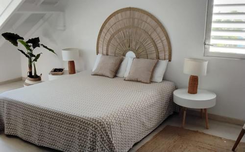 a bedroom with a large bed with a wooden headboard at Orient Bay 2 Bedroom beach appartement in Orient Bay