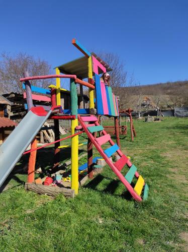 a playground with a colorful slide in a field at Szofi Vendégház in Kereki