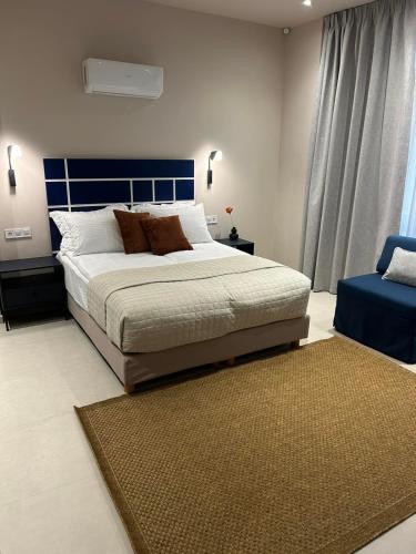 a bedroom with a large bed with a blue headboard at Living Yard Thissio in Athens