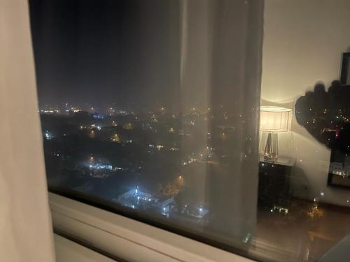 a window with a view of a city at night at Gold crest Mall & Residence in Lahore