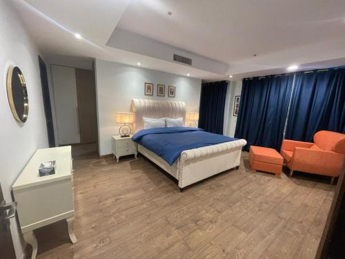 a bedroom with a bed and an orange couch at Gold crest Mall & Residence in Lahore