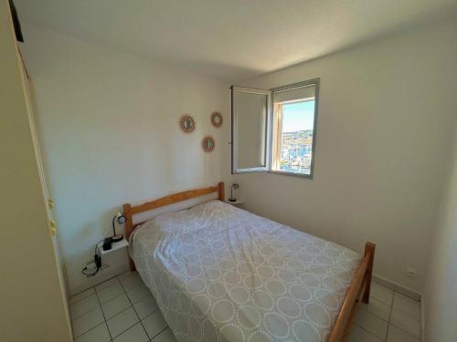 une petite chambre avec un lit et une fenêtre dans l'établissement T2 cabine 4 pers. près plage, parking, vue port - Argelès - FR-1-388-90, à Argelès-sur-Mer