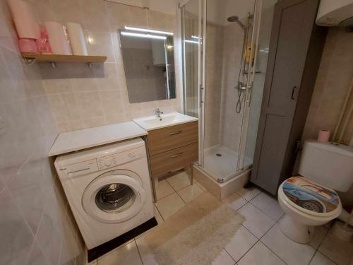 une salle de bain avec machine à laver et toilettes dans l'établissement Appartement lumineux 2 pièces avec terrasse, à 50m de la plage, 6 couchages, 34300 Agde - FR-1-423-177, au Grau-dʼAgde