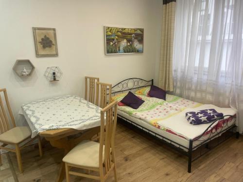 1 Schlafzimmer mit 2 Betten, einem Tisch und Stühlen in der Unterkunft Cichy Zaułek 8 in Brodnica
