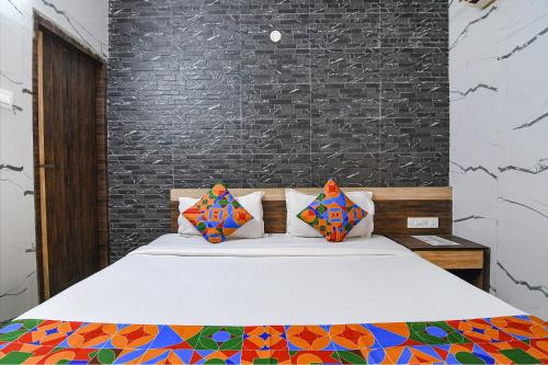 a bedroom with a bed with colorful pillows at FabExpress Subh Residency in Sāntrāgāchi