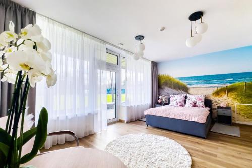 a living room with a bed and a view of the ocean at WHITE HOUSE in Jastrzębia Góra