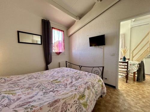 une chambre avec un lit, une télévision et une fenêtre dans l'établissement Appartement 2 pièces mezzanine climatisé avec terrasse - 450m de la plage, parking inclus, Saint Cyprien - FR-1-225D-149, à Saint-Cyprien