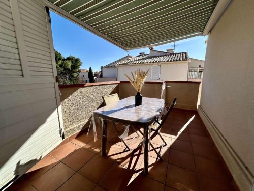 une table et des chaises sur le balcon d'une maison dans l'établissement Appartement 2 pièces mezzanine climatisé avec terrasse - 450m de la plage, parking inclus, Saint Cyprien - FR-1-225D-149, à Saint-Cyprien