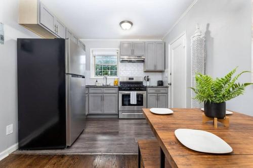 a kitchen with a wooden table and a black refrigerator at King Bed Apt in West Hartford - Sleep 04 in Great Neighborhood in West Hartford