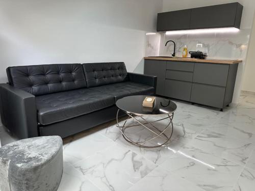 a living room with a black couch and a table at Cozy apartment in Monaco center in Monte Carlo