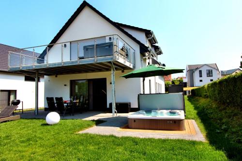 uma casa com uma banheira de hidromassagem no quintal em Luxus_EG_Fewo TEE ONE em Göhren-Lebbin