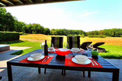 una mesa negra con servilletas rojas y copas de vino en Luxus_EG_Fewo TEE ONE, en Göhren-Lebbin