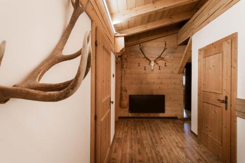 a hallway with a room with a television and antlers on the wall at Chalet Edelweiß in Saalbach Hinterglemm