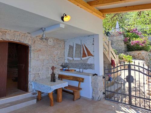 een terras met een tafel en een zeil aan de muur bij Robinson Ane in Gdinj