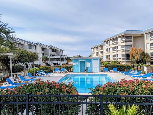 a swimming pool with chairs and a resort at Casa Wanderlust at Harbor Island K204 in Oceanmarsh Subdivision