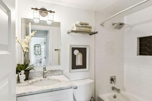 a white bathroom with a sink and a tub at Spacious Modern Condo Near Crystal City Metro in Arlington