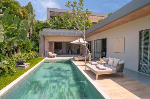 a backyard with a swimming pool and a house at Sin Nombre Bali - Sauna, Ice Bath & Roof Terrace in Canggu