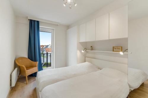 um quarto com 2 camas e uma janela em Sunrise A1 em De Haan