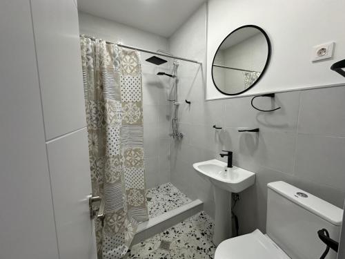 a white bathroom with a shower and a sink at Hotel Home in Tbilisi City