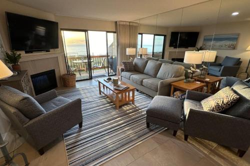 una gran sala de estar con sofás y chimenea. en Full Ocean View-2 Decks-Heated Pools, en Aptos