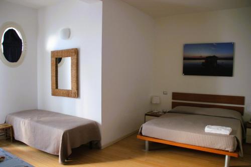 a bedroom with two beds and a mirror at Residence Rivaverde in Marina di Ravenna